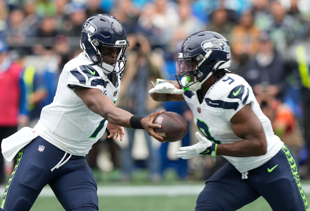 Geno Smith #7 of the Seattle Seahawks hands the ball off to Kenneth Walker III #9 of the Seattle Se...