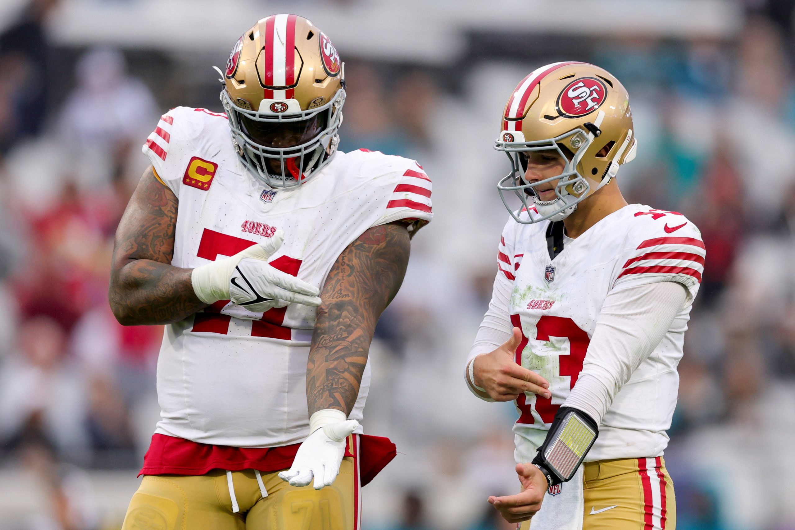 Trent Williams #71 and Brock Purdy #13 of the San Francisco 49ers celebrate a touchdown against the...