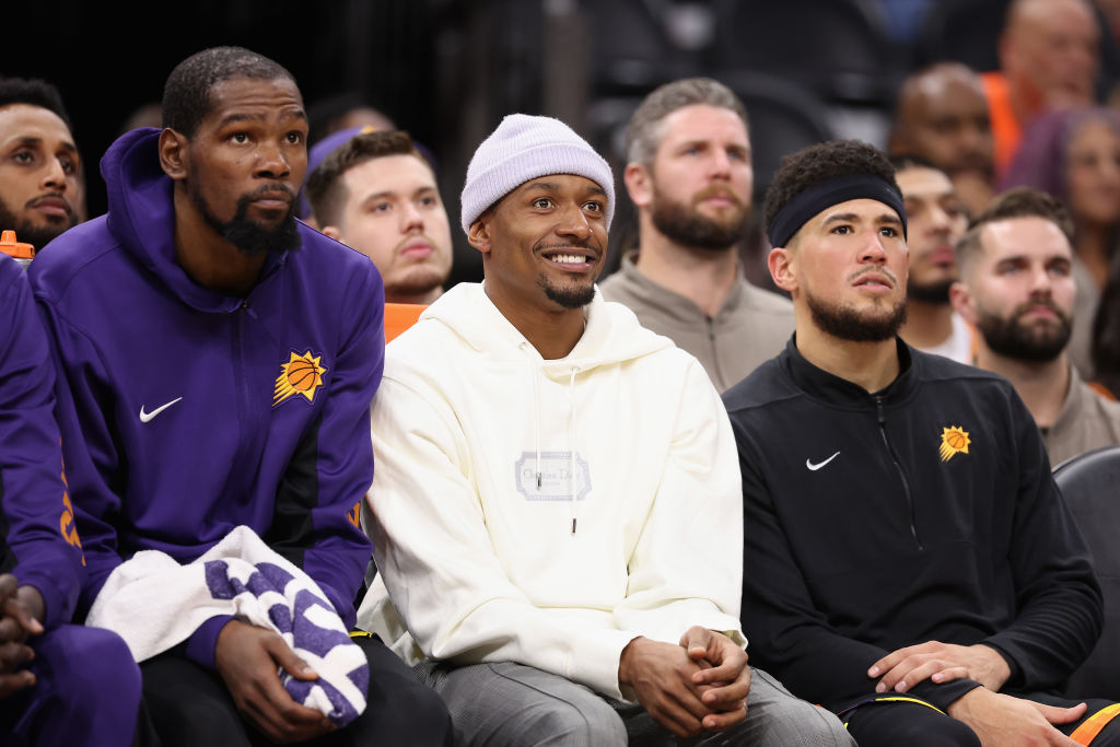 Kevin Durant #35, Bradley Beal #3 and Devin Booker #1 of the Phoenix Suns watch from the bench duri...