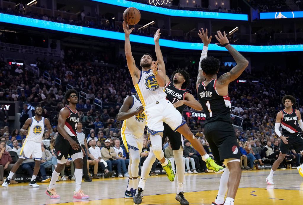 Stephen Curry #30 of the Golden State Warriors drives to the basket against Shaedon Sharpe #17 of t...