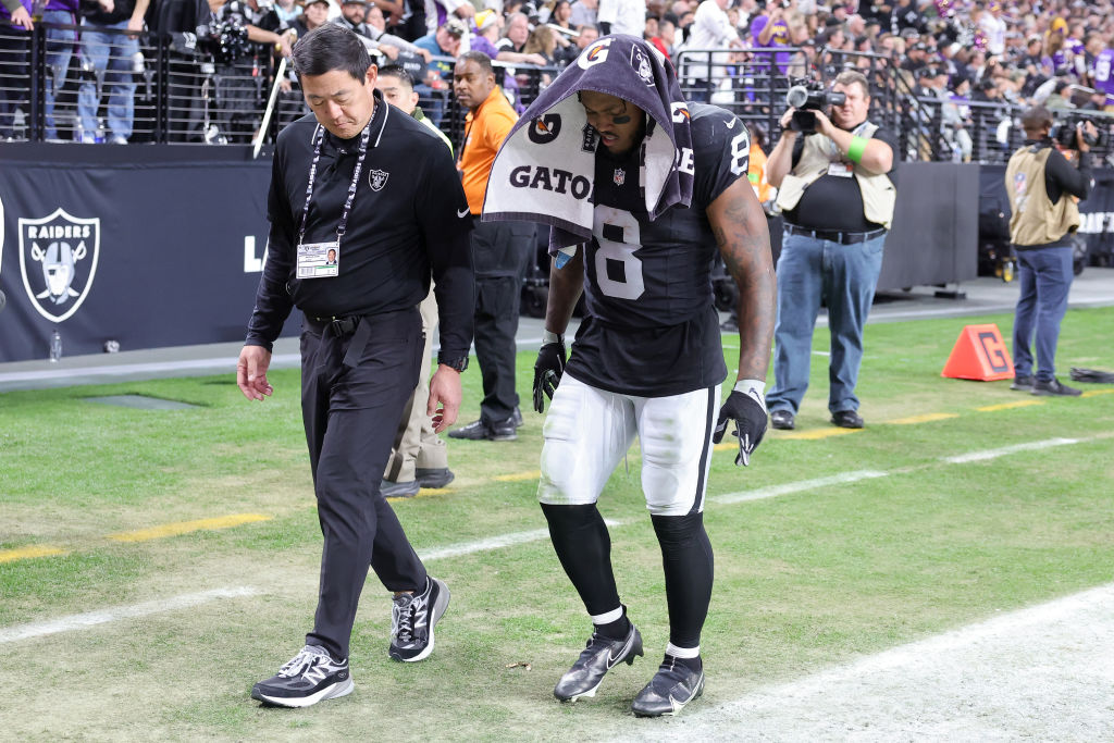 Dr. Michael Miao walks with Josh Jacobs #8 of the Las Vegas Raiders as he leaves the field after an...
