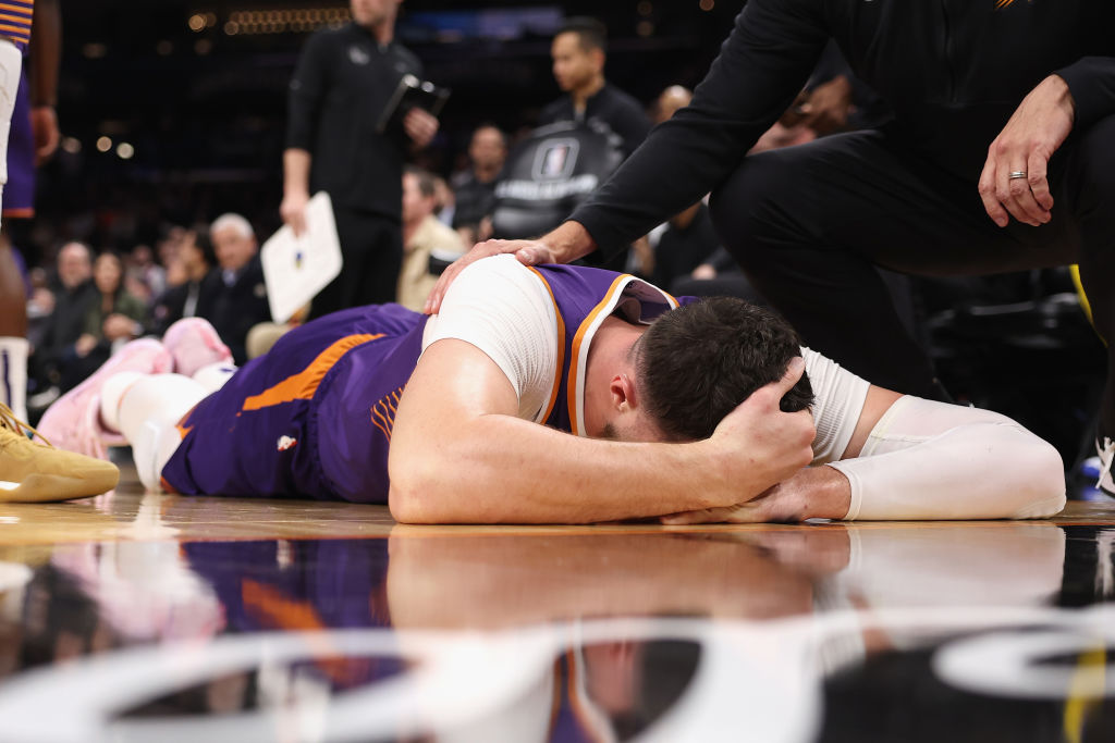 Jusuf Nurkic #20 of the Phoenix Suns lays on the court after being fouled by Draymond Green (not pi...