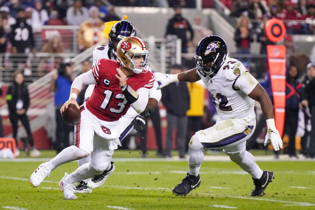 Brock Purdy #13 of the San Francisco 49ers attempts a pass while pressured by Justin Madubuike #92 ...