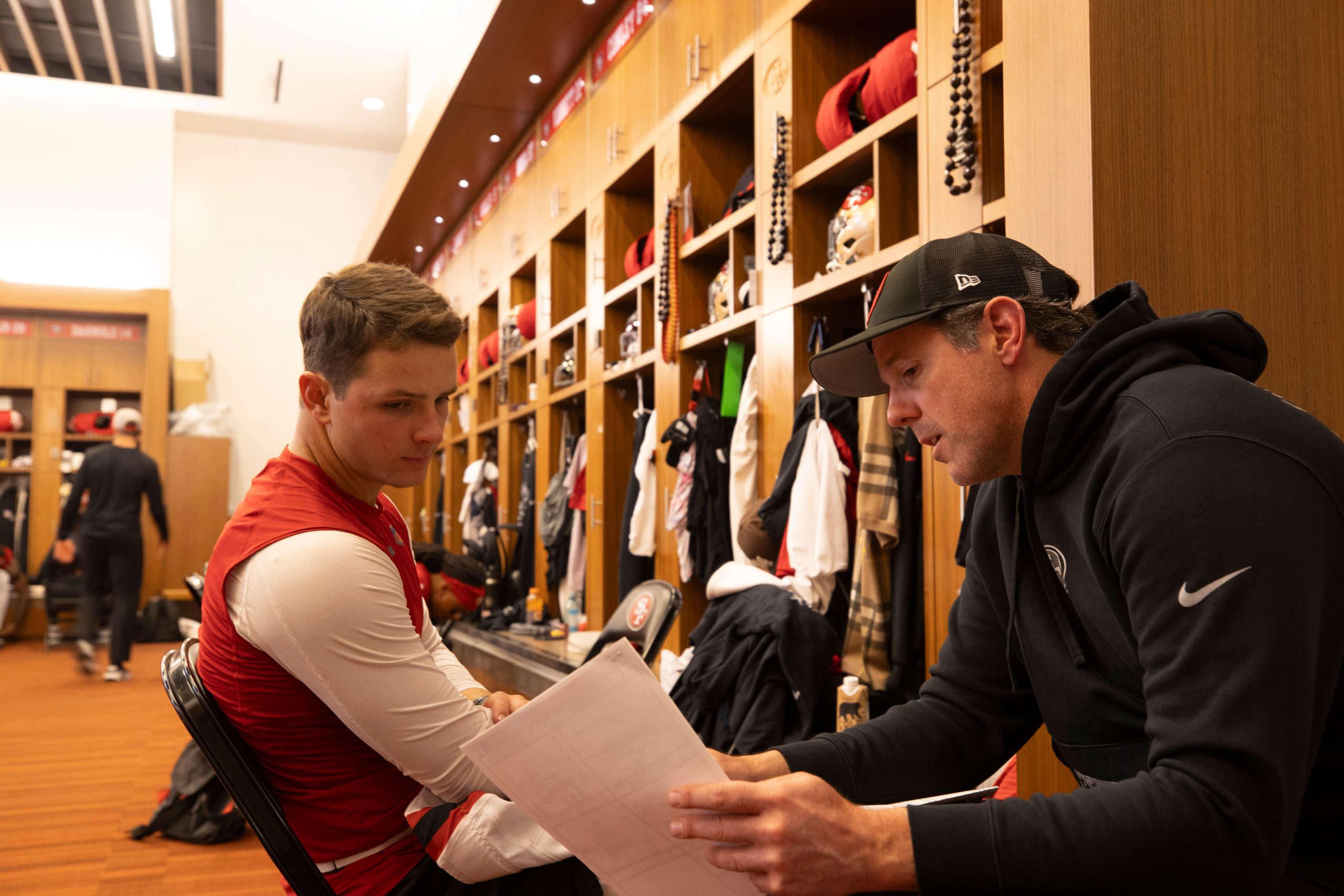 Brock Purdy #13 and Quarterbacks Coach Brian Griese of the San Francisco 49ers in the locker room b...