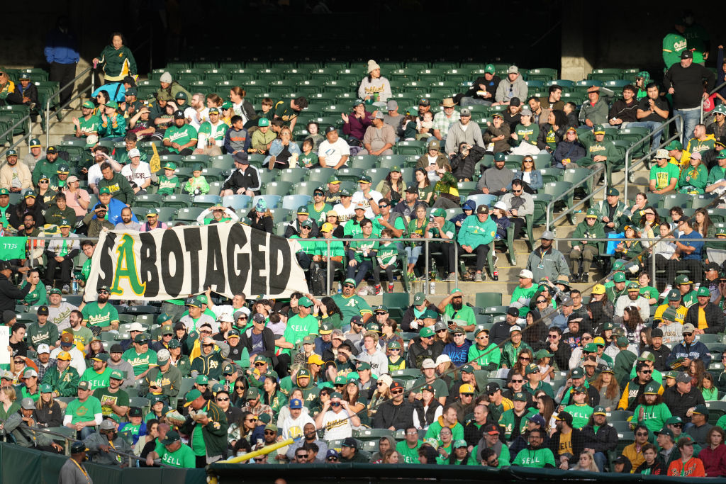 Oakland Athletics fans display signs during a reverse boycott game against the Tampa Bay Rays at Ri...