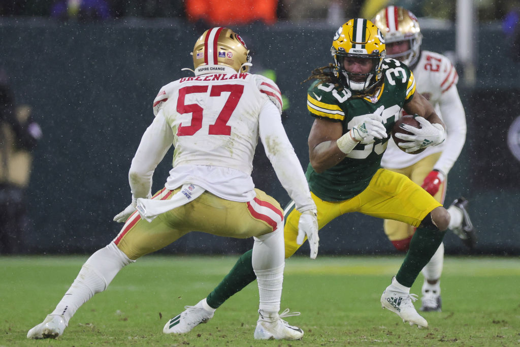 Aaron Jones #33 of the Green Bay Packers carries the ball as Dre Greenlaw #57 of the San Francisco ...