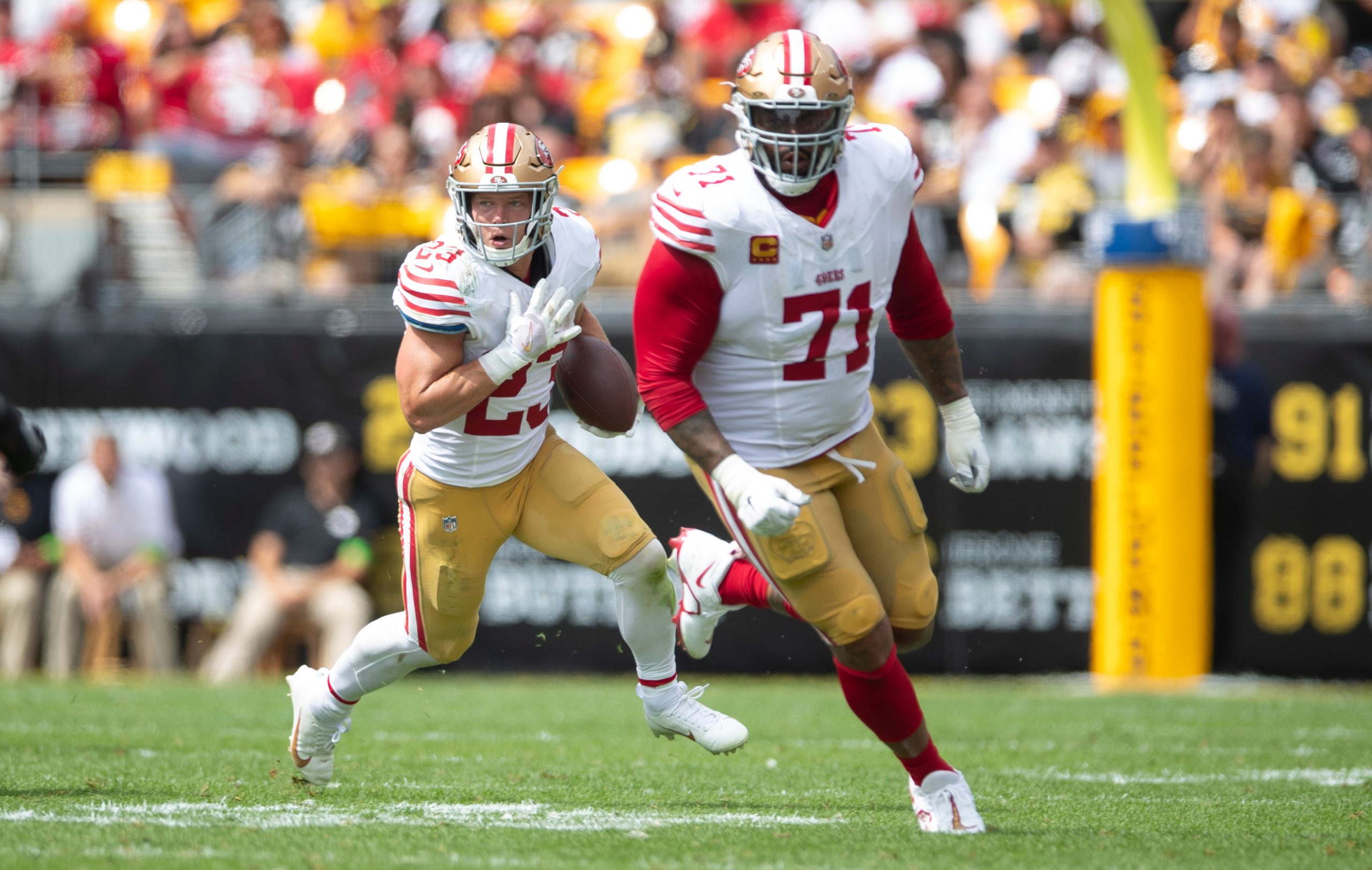 Christian McCaffrey #23 of the San Francisco 49ers rushes as Trent Williams #71 blocks during the g...