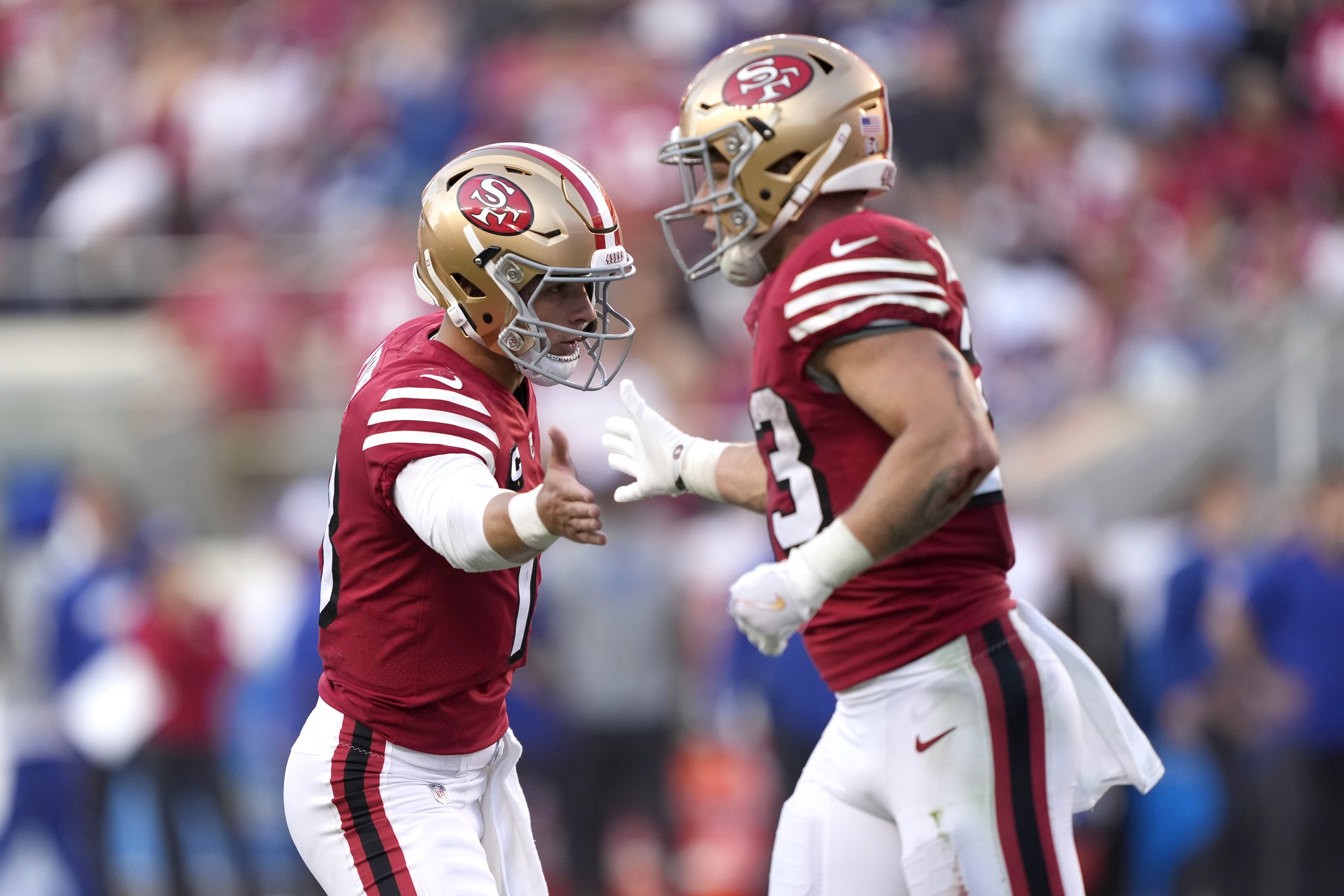 Brock Purdy #13 and Christian McCaffrey #23 of the San Francisco 49ers celebrate a play against the...
