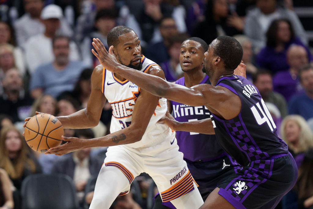 SACRAMENTO, CALIFORNIA - DECEMBER 22: Kevin Durant #35 of the Phoenix Suns is guarded by Harrison B...