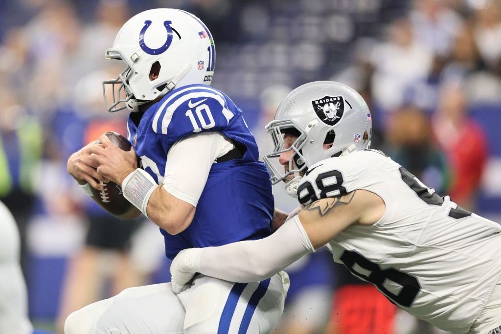 Gardner Minshew #10 of the Indianapolis Colts is tackled by Maxx Crosby #98 of the Las Vegas Raider...