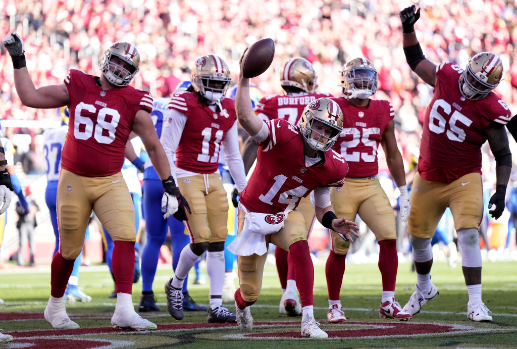 Sam Darnold #14 of the San Francisco 49ers celebrates with teammates after a touchdown run in the s...
