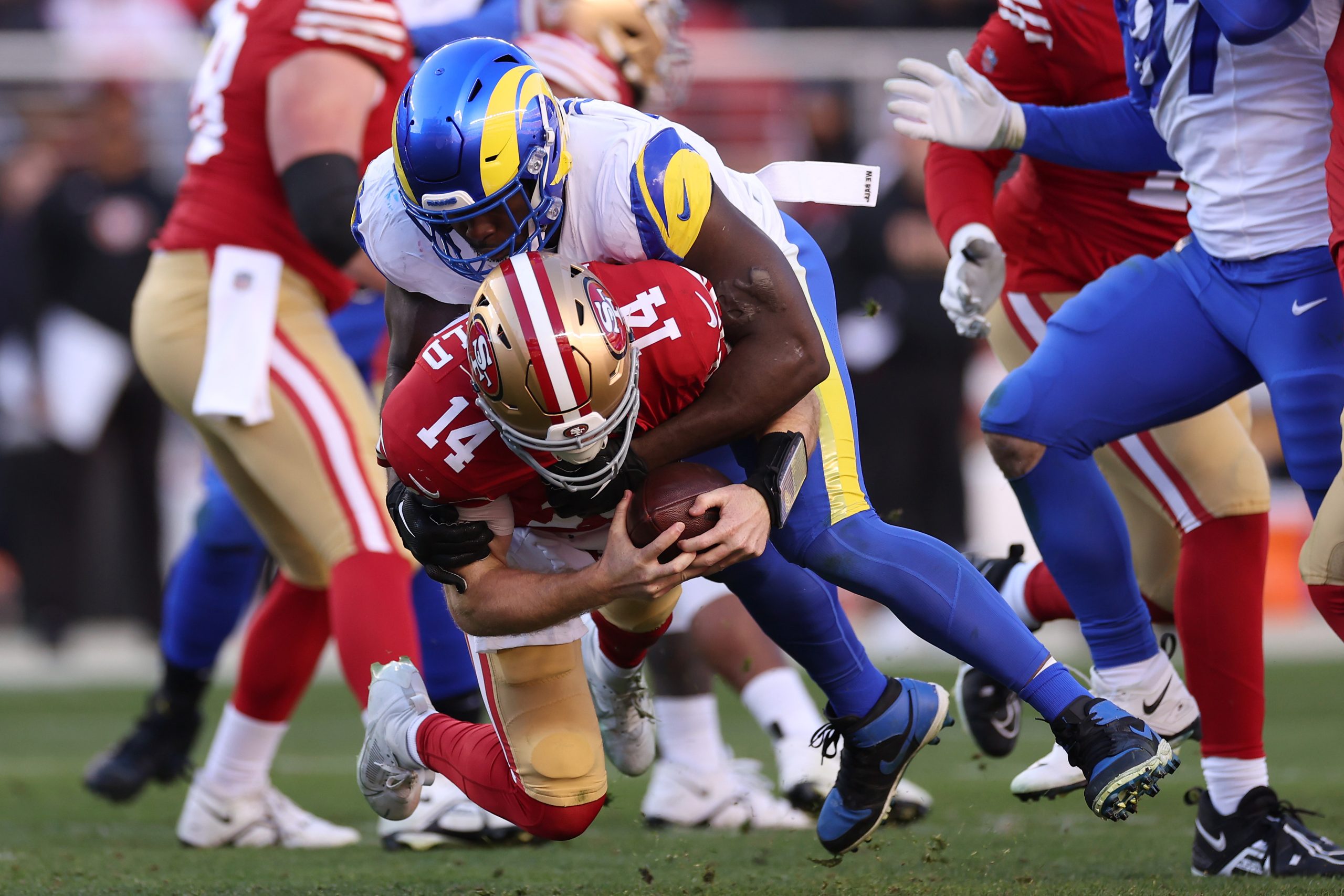 Byron Young #0 of the Los Angeles Rams sacks Sam Darnold #14 of the San Francisco 49ers in the four...