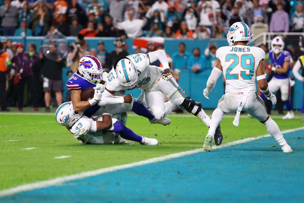 Ty Johnson #26 of the Buffalo Bills is tackled by Eli Apple #33 of the Miami Dolphins during the se...