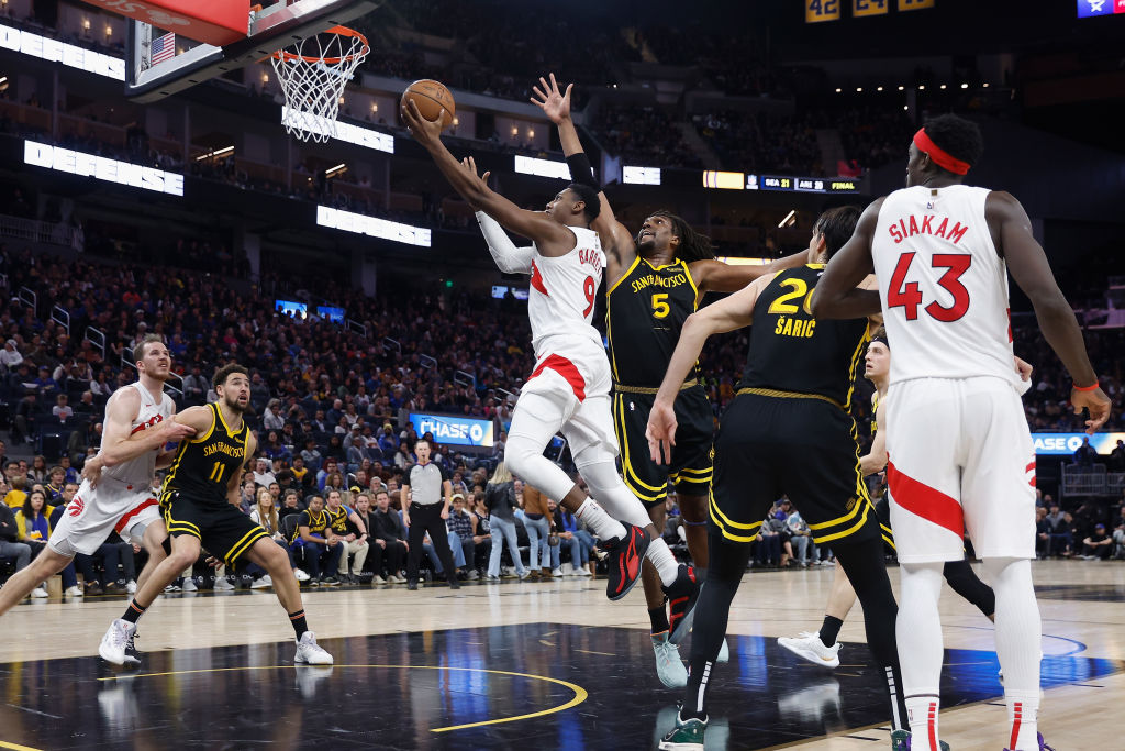 RJ Barrett #9 of the Toronto Raptors goes to the basket against Kevon Looney #5 of the Golden State...