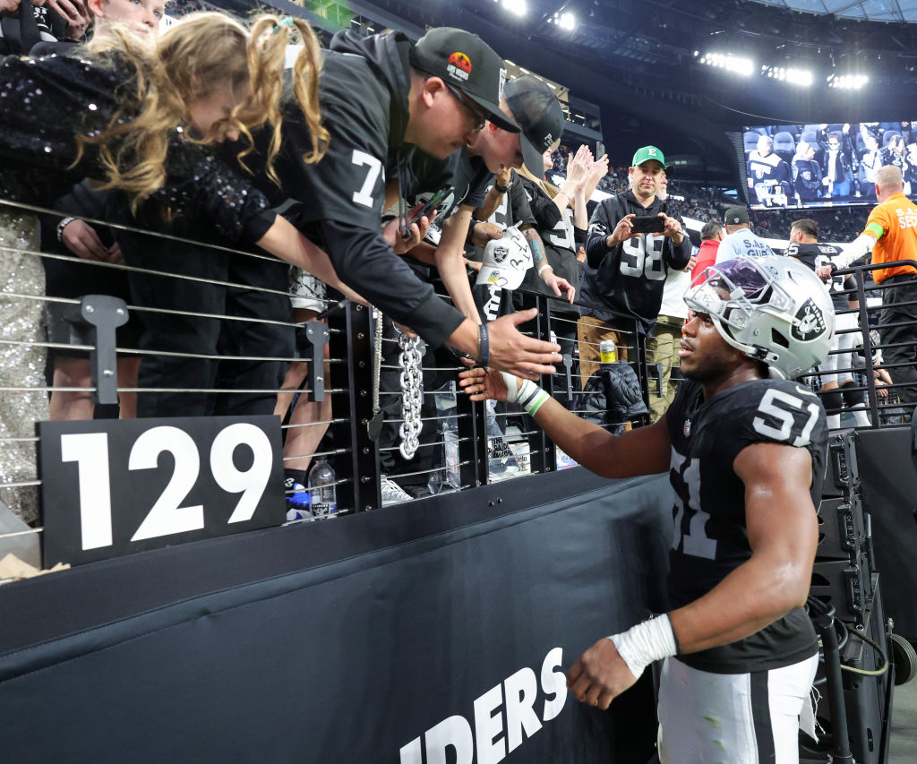 Defensive end Malcolm Koonce #51 of the Las Vegas Raiders signs autographs for fans after the team'...