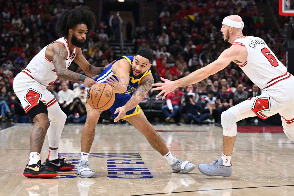 Cory Joseph #1 of the Golden State Warriors passes off the ball while being defended by Coby White ...