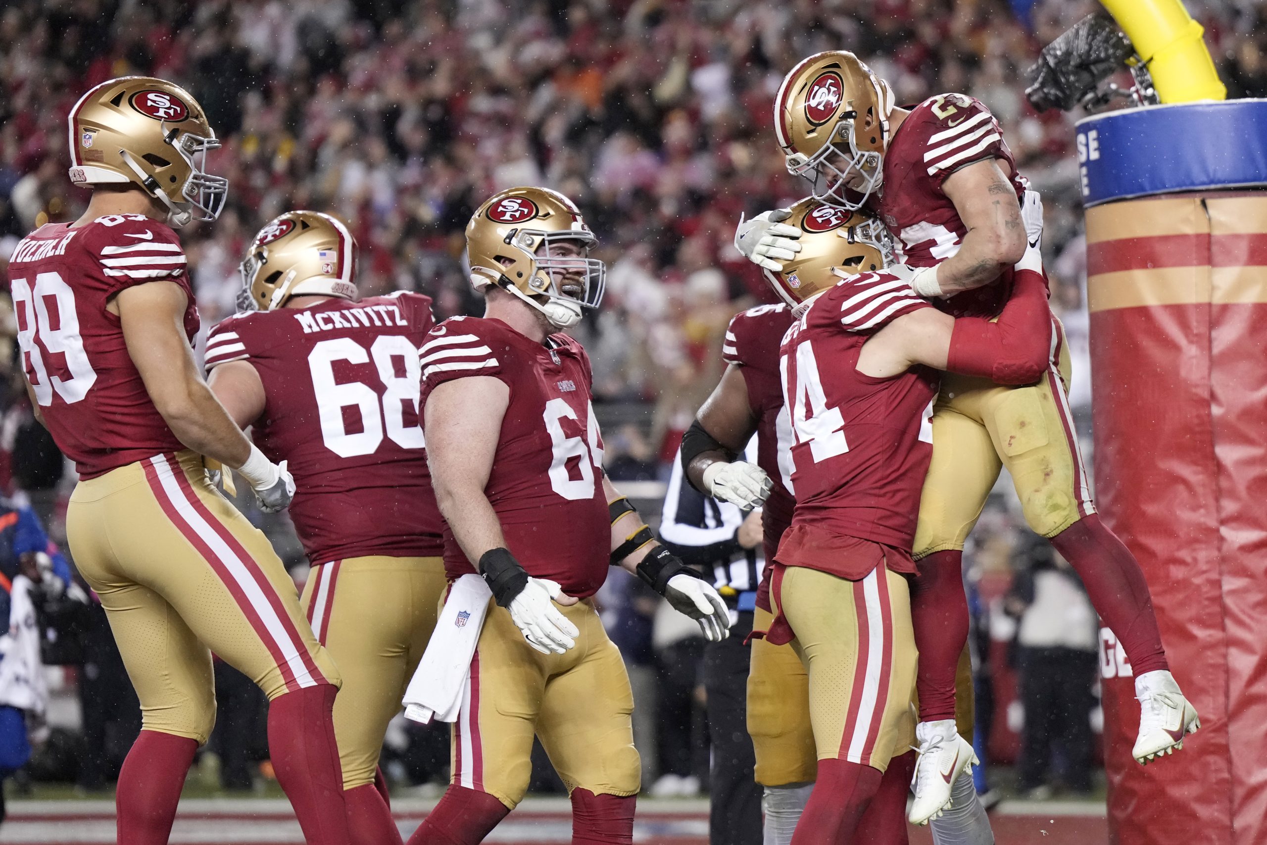 Christian McCaffrey #23 of the San Francisco 49ers celebrates with teammates after scoring a 6-yard...