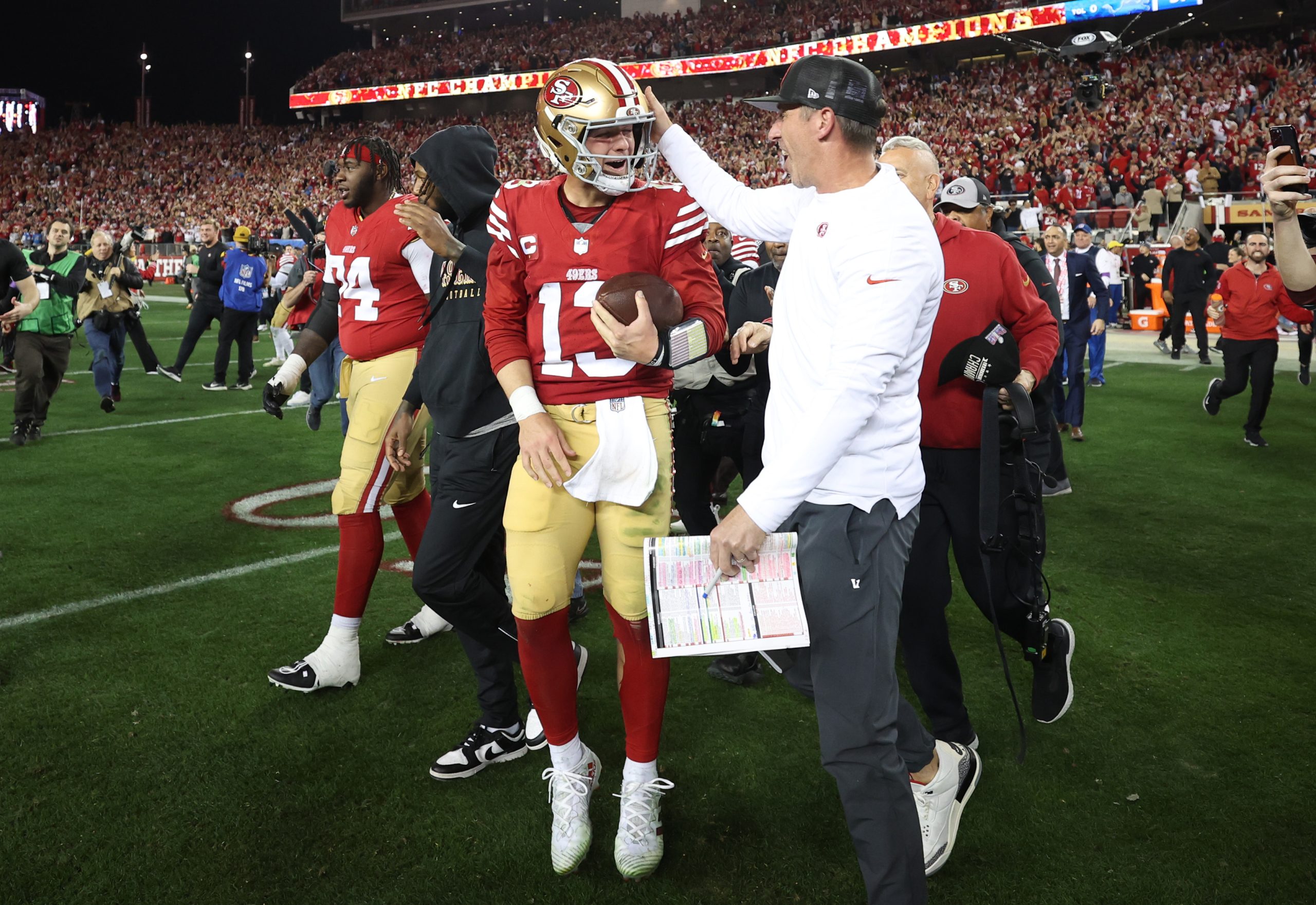 Brock Purdy #13 of the San Francisco 49ers celebrates with Head coach Kyle Shanahan after defeating...