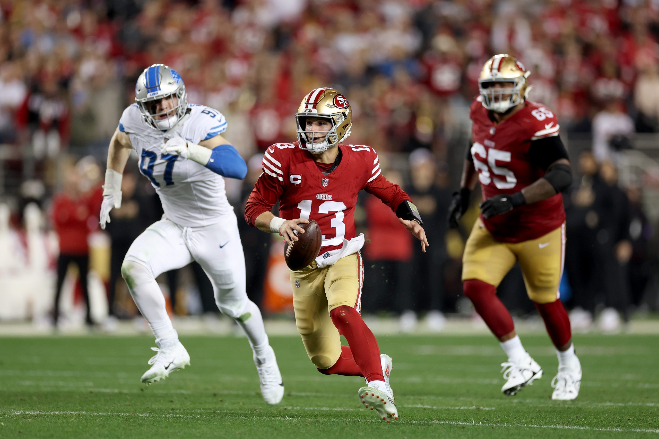 Brock Purdy #13 of the San Francisco 49ers scrambles with the ball against the Detroit Lions in the...