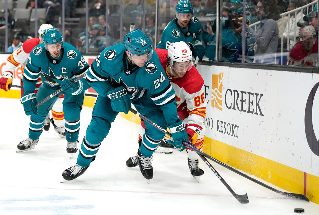 Jaycob Megna #24 of the San Jose Sharks and Andrew Mangiapane #88 of the Calgary Flames skates for ...