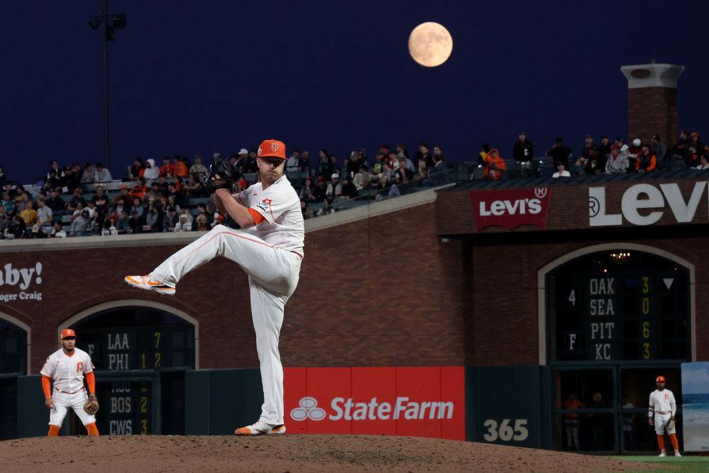 Alex Cobb #38 of the San Francisco Giants pitches against the Cincinnati Reds as a almost full moon...