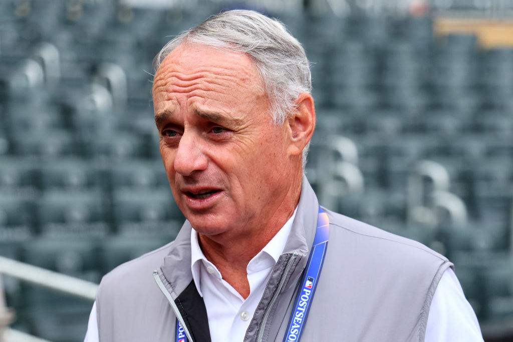 Major League Baseball Commissioner Robert D. Manfred Jr. talks prior to Game Two of the Wild Card S...