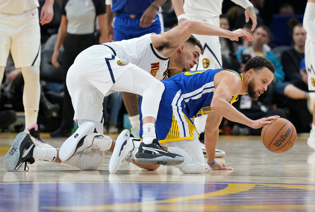 Stephen Curry #30 of the Golden State Warriors controls the ball against Michael Porter Jr. #1 of t...