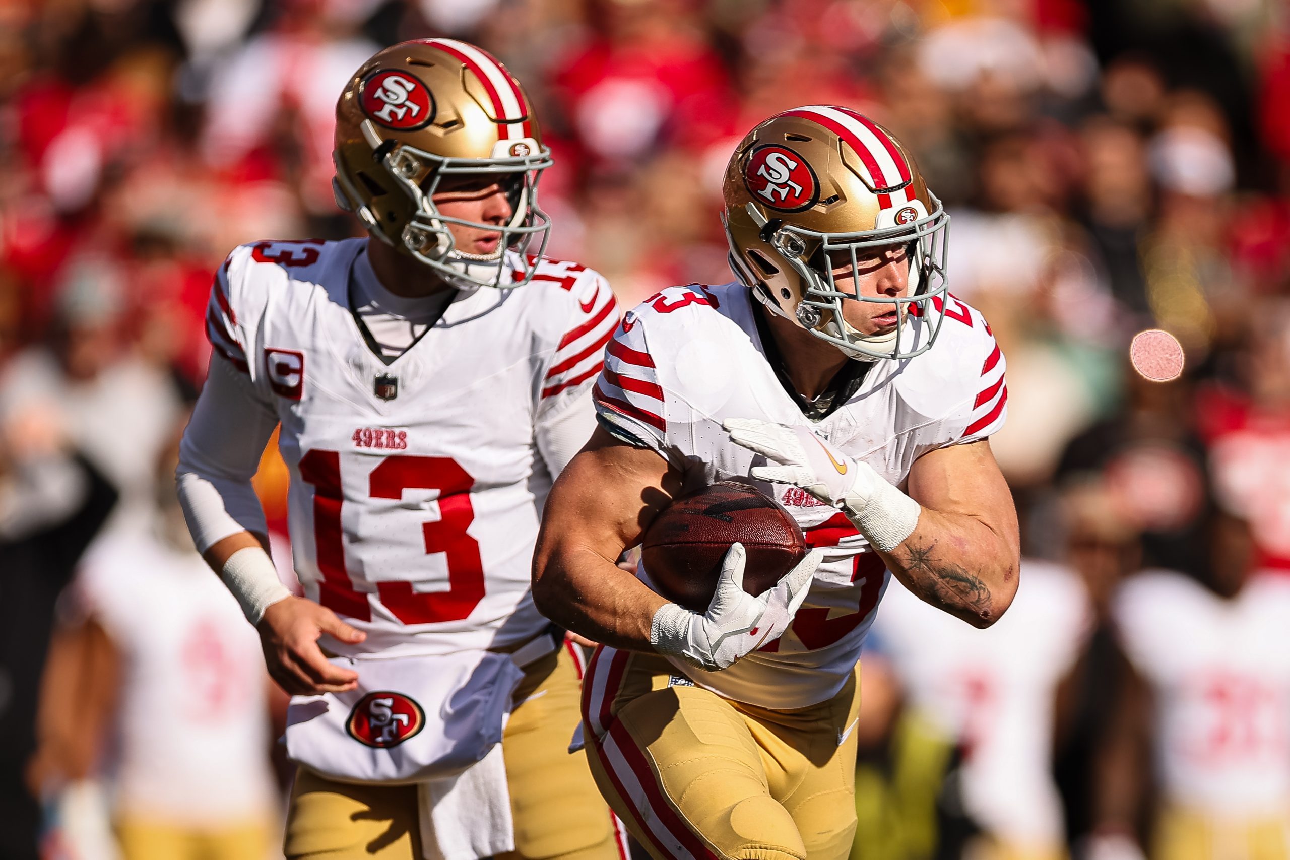 Brock Purdy #13 (L) of the San Francisco 49ers hands the ball off to Christian McCaffrey #23 during...