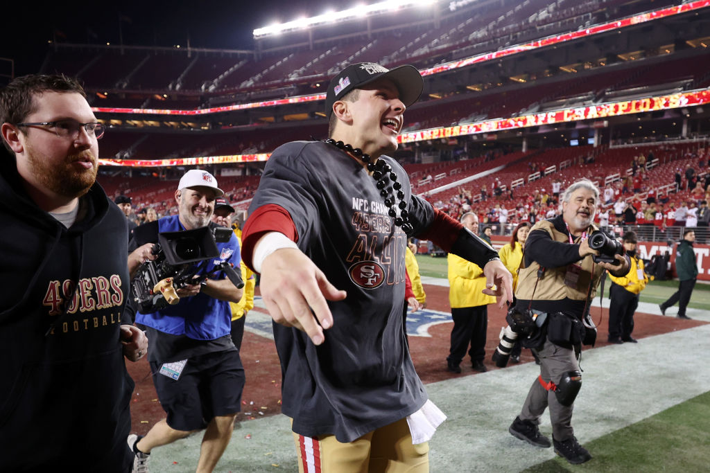 Brock Purdy #13 of the San Francisco 49ers reacts as he runs back to the locker room after defeatin...