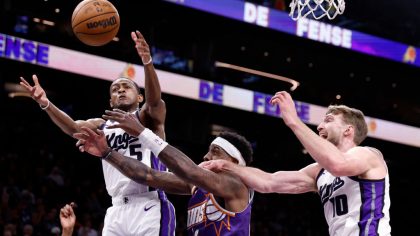 PHOENIX, ARIZONA - FEBRUARY 13: Royce O'Neale #00 of the Phoenix Suns attempts to control a rebound against Domantas Sabonis #10 and De'Aaron Fox #5 of the Sacramento Kings during the first half at Footprint Center on February 13, 2024 in Phoenix, Arizona. NOTE TO USER: User expressly acknowledges and agrees that, by downloading and or using this photograph, User is consenting to the terms and conditions of the Getty Images License Agreement. (Photo by Chris Coduto/Getty Images)