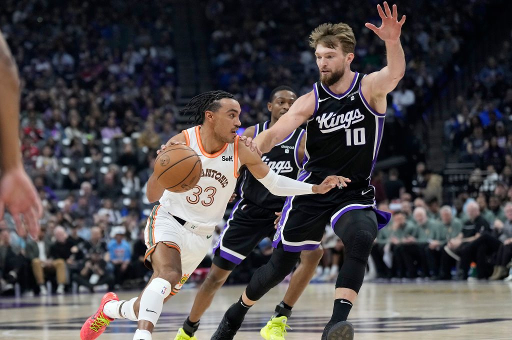 Tre Jones #33 of the San Antonio Spurs drives on Domantas Sabonis #10 of the Sacramento Kings in th...