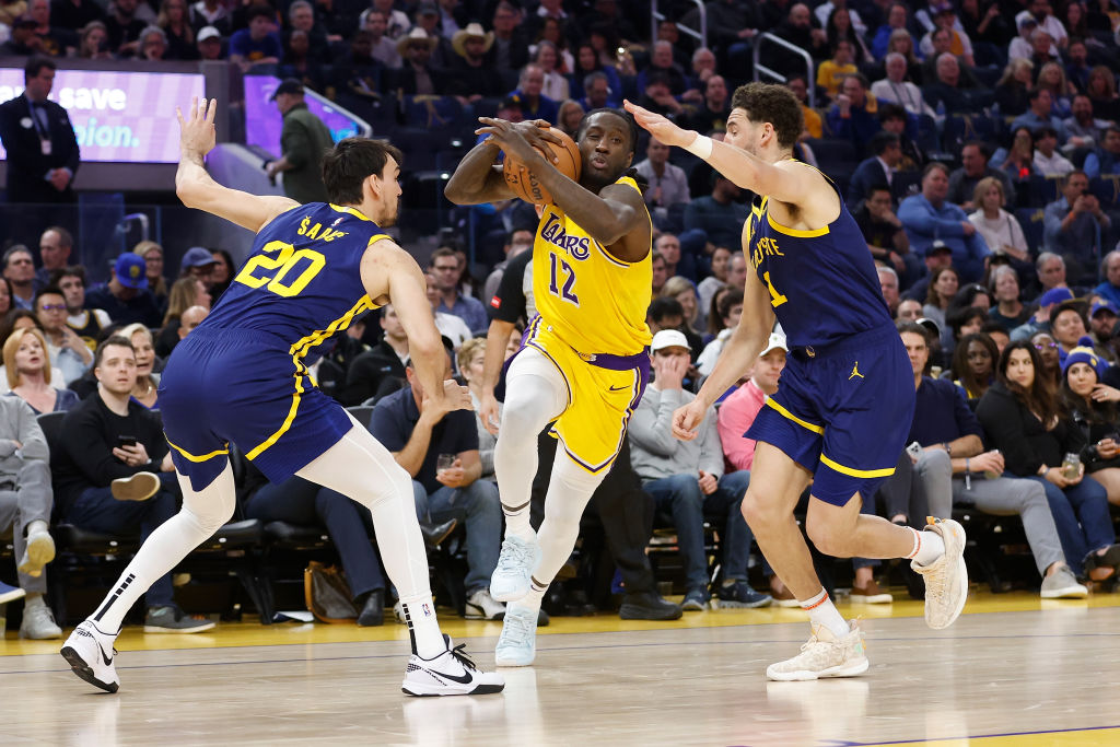 Taurean Prince #12 of the Los Angeles Lakers drives to the basket against Dario Saric #20 and Klay ...