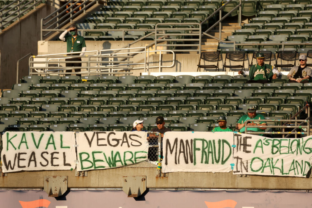 Oakland Athletics fans hang signs that against the management and ownership of the team during thei...