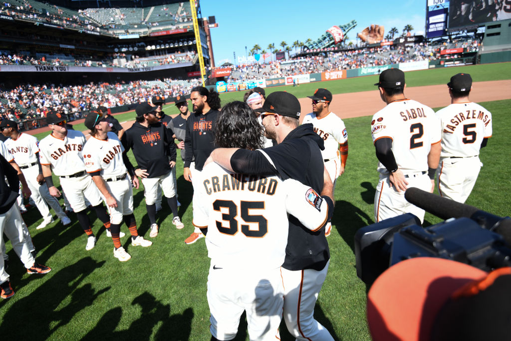Brandon Crawford #35 of the San Francisco Giants hugs his team after his final baseball game agains...