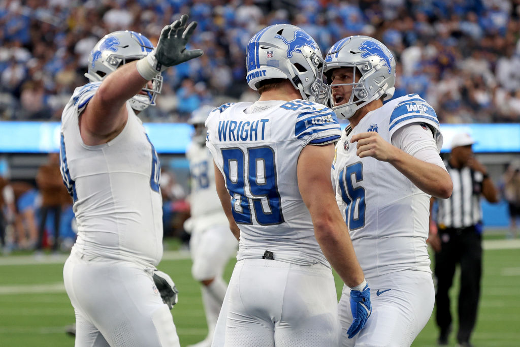 Jared Goff #16 of the Detroit Lions celebrates a touchdown pass with Brock Wright #89 of the Detroi...
