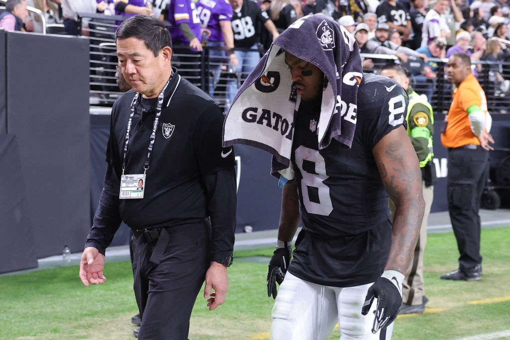 Dr. Michael Miao walks with Josh Jacobs #8 of the Las Vegas Raiders as he leaves the field after an...