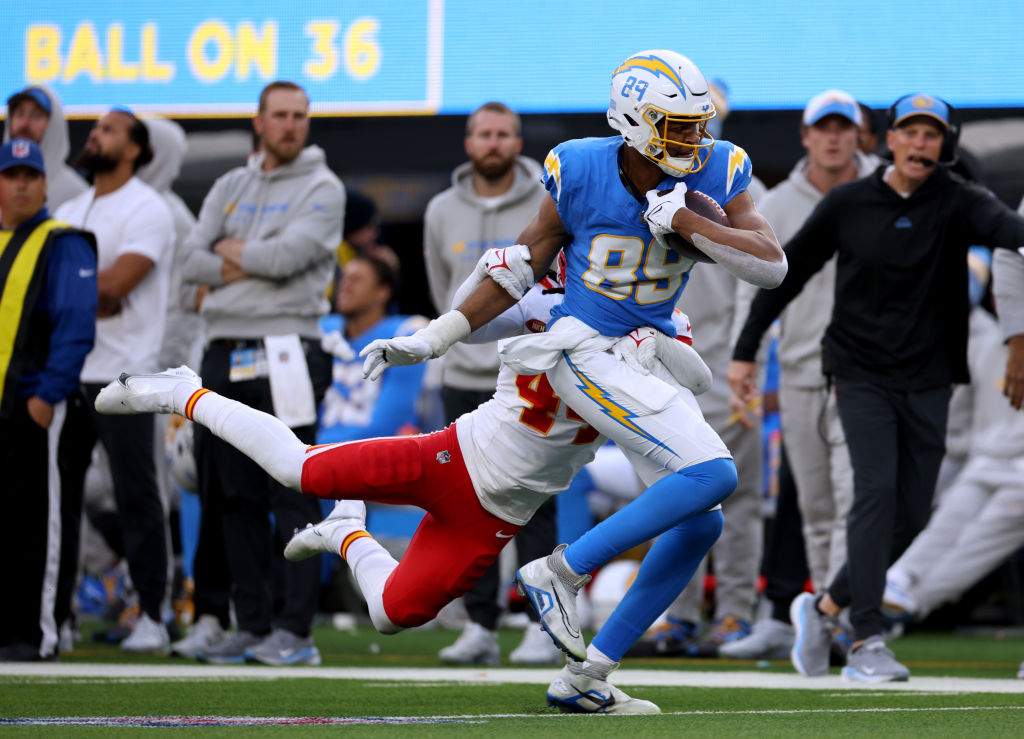 Donald Parham Jr. #89 of the Los Angeles Chargers runs after his catch as he is tackled by Cam Jone...