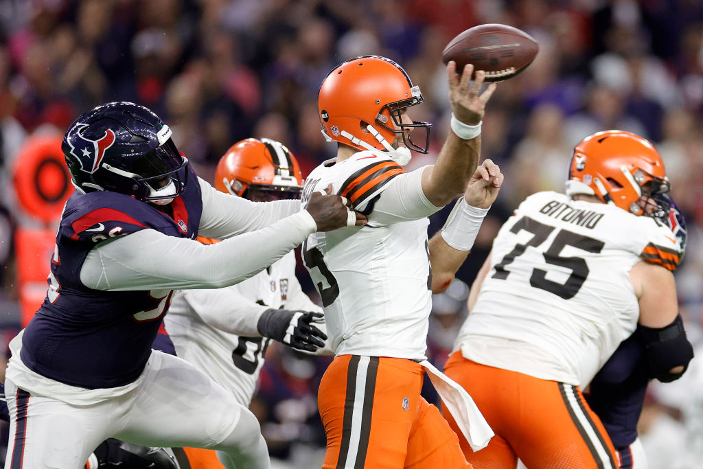 Joe Flacco #15 of the Cleveland Browns throws a pass while being pressured by Maliek Collins #96 of...