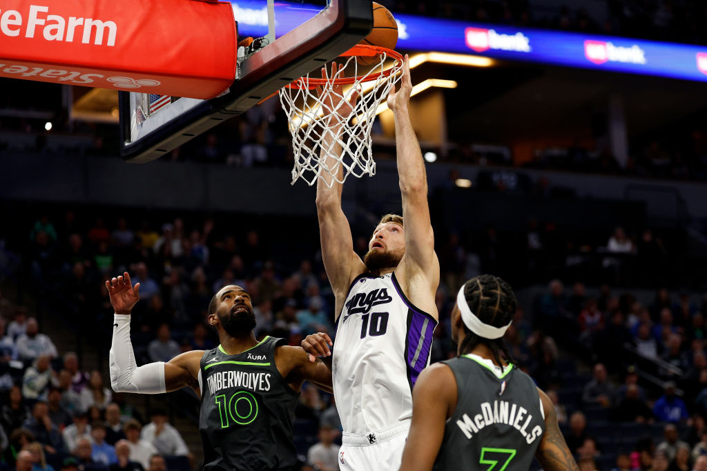 Domantas Sabonis #10 of the Sacramento Kings goes up for a shot against Mike Conley #10 and Jaden M...