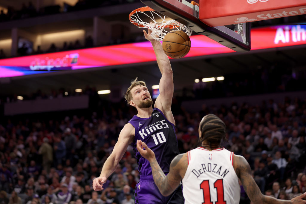 Domantas Sabonis #10 of the Sacramento Kings goes up for a dunk on DeMar DeRozan #11 of the Chicago...