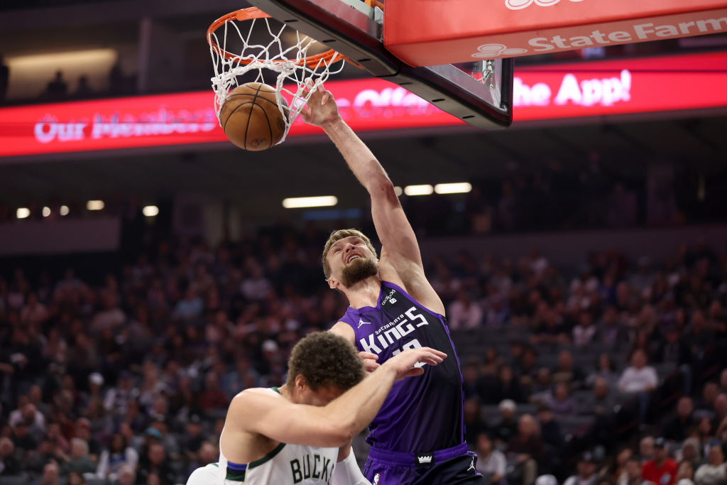 Domantas Sabonis #10 of the Sacramento Kings goes up for a dunk on Brook Lopez #11 of the Milwaukee...