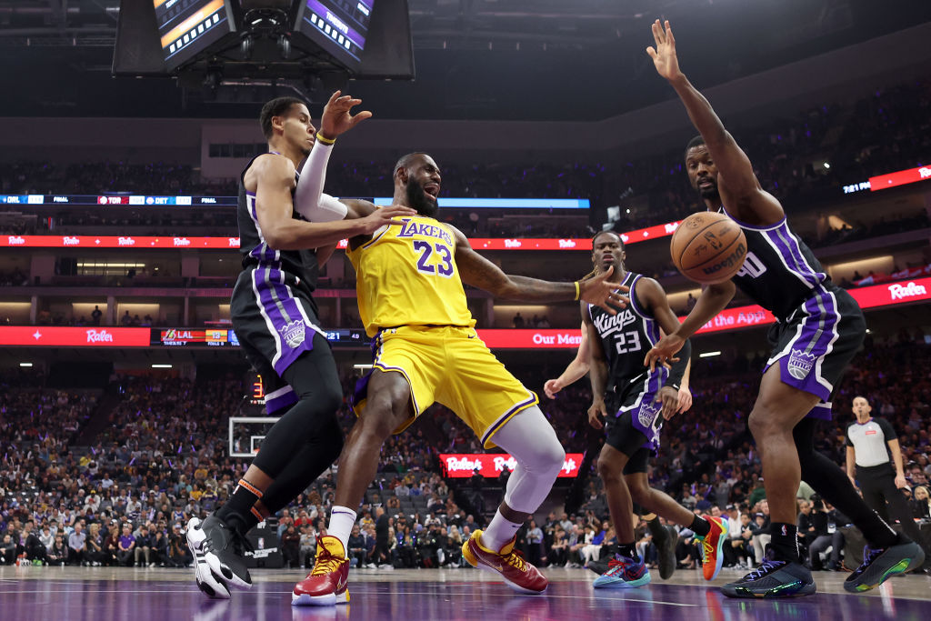 LeBron James #23 of the Los Angeles Lakers goes for a loose ball against Keegan Murray #13 and Harr...