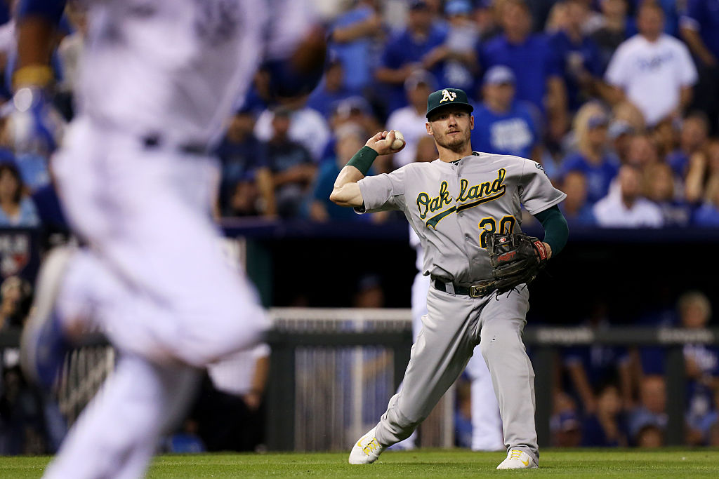 Josh Donaldson #20 of the Oakland Athletics throws to first for the out on Alcides Escobar #2 of th...