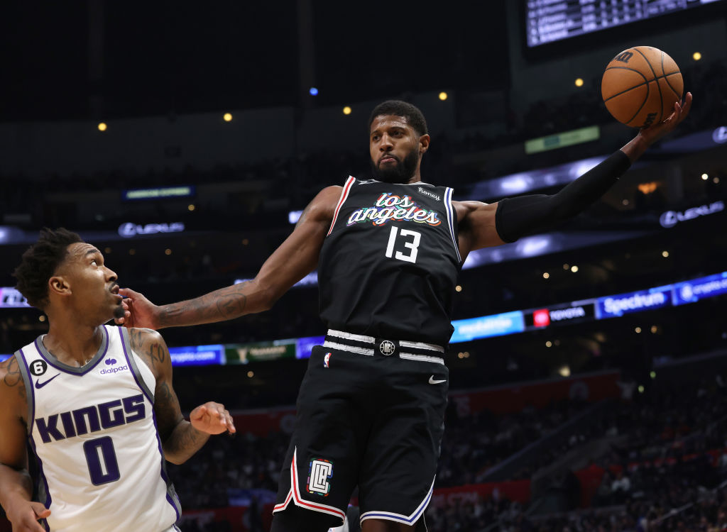 Paul George #13 of the LA Clippers saves a ball in front of Malik Monk #0 of the Sacramento Kings d...