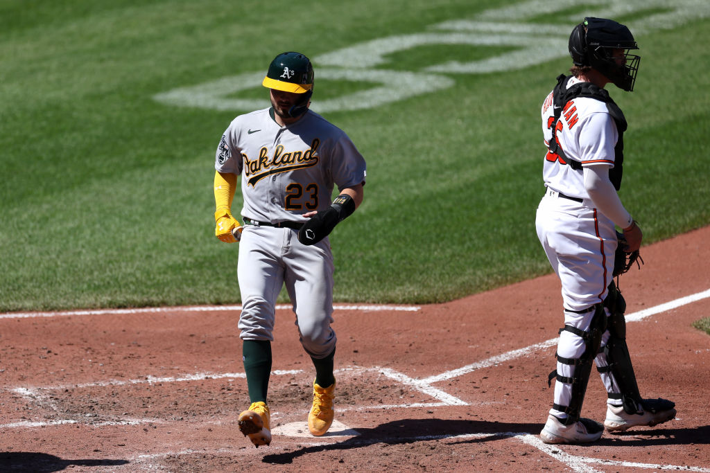 BALTIMORE, MARYLAND - APRIL 13: Shea Langeliers #23 of the Oakland Athletics scores a run in front ...