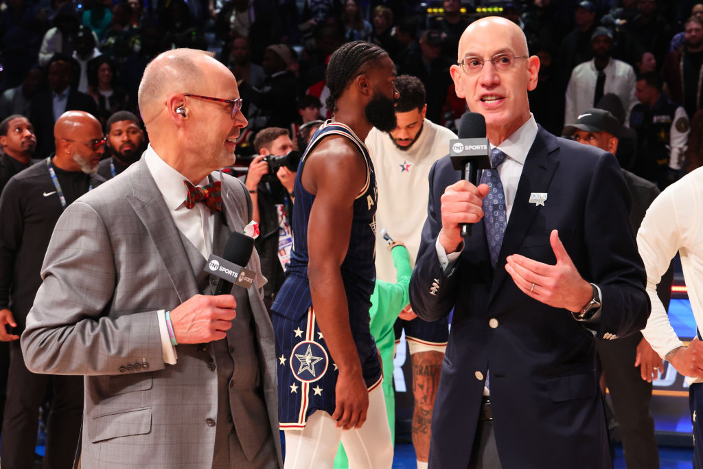 Ernie Johnson Jr. and NBA Commissioner Adam Silver speak on the court during the 2024 NBA All-Star ...