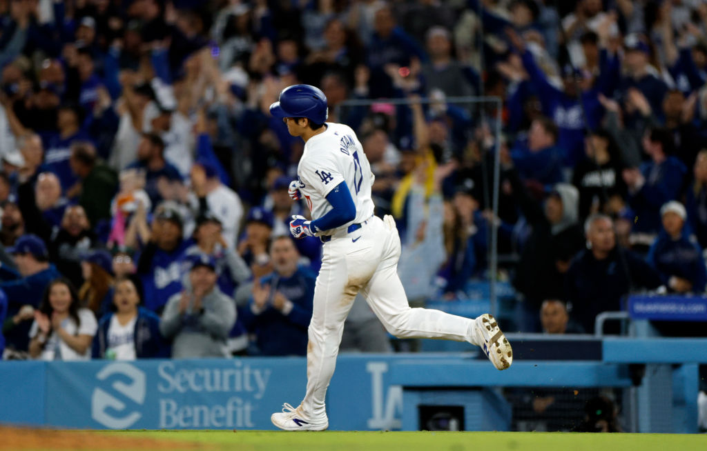 Shohei Ohtani #17 of the Los Angeles Dodgers returns to the dugout after hitting a solo home run du...