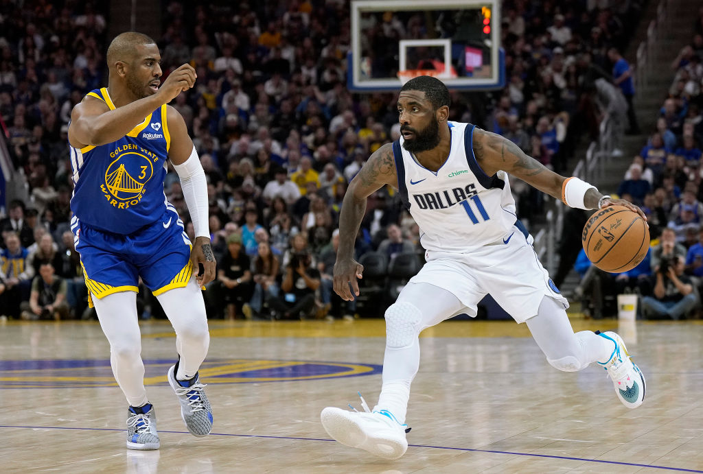 Kyrie Irving #11 of the Dallas Mavericks is guarded by Chris Paul #3 of the Golden State Warriors d...