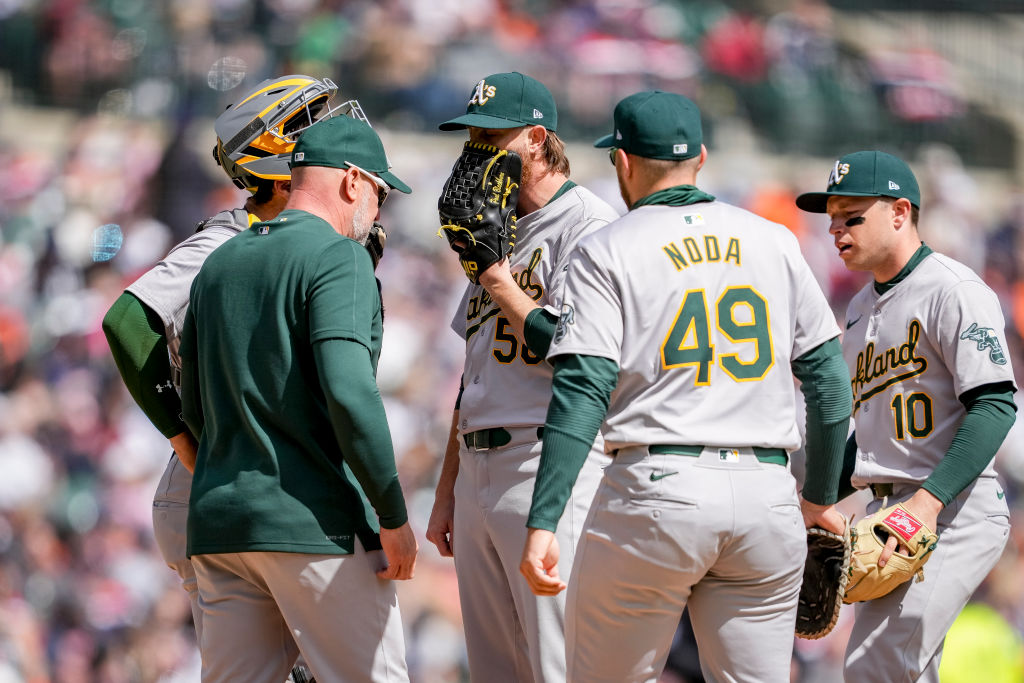 Pitcher Paul Blackburn #58 of the Oakland Athletics is met by teammates and coaches on the mound ag...