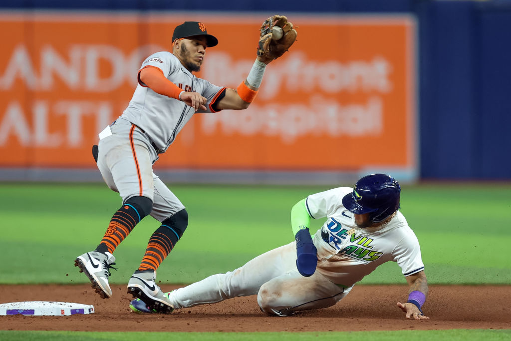 Harold Ramírez #43 of the Tampa Bay Rays slides in safely with a steal under the tag of Thairo Est...